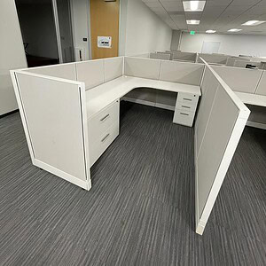 Modern white office cubicles with beige accents in a corporate workspace.