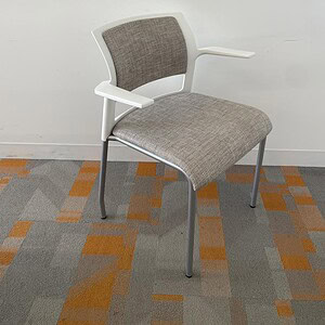 Steelcase Cobi stacking chair in white with neutral fabric upholstery, ideal for modern office space.