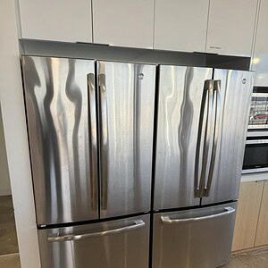 Stainless steel G.E. refrigerator with French doors and bottom freezer, ideal for modern kitchens.