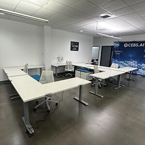 Office workspace with white desks and ergonomic chairs in a professional environment.