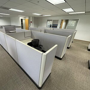 Modern beige office cubicles in a spacious workspace environment.
