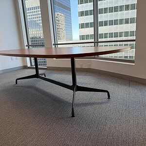 Modern Herman Miller Eames conference table in a bright office space.