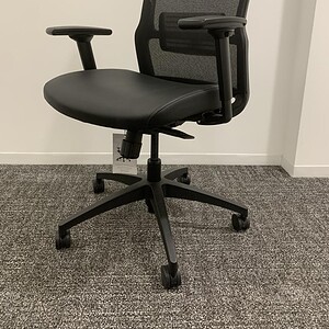 Office ergonomic chair with adjustable armrests and mesh backrest.