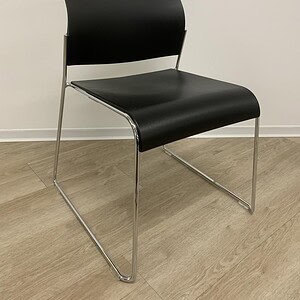 Modern black stacking sled chair with chrome legs, ideal for office or conference rooms.
