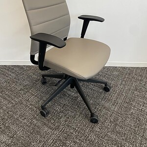 Office chair with beige fabric upholstery, black armrests, and adjustable height, ideal for modern w.