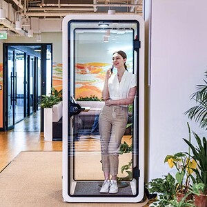 Privacy pod with glass walls in black, white, and green colors for modern office or personal use.