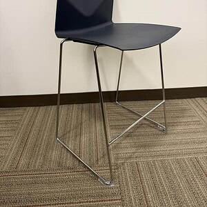 Black stackable bar stool with sleek design and metal legs.