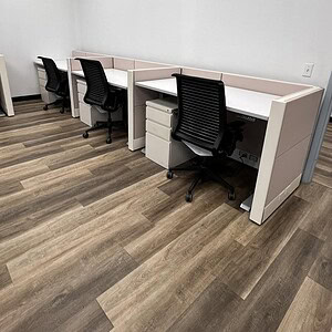 Adjustable Ethospace workstations with privacy panels and ergonomic chairs in a professional office.