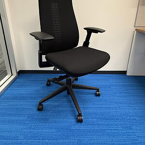 Black ergonomic office chair with adjustable armrests and lumbar support for optimal comfort.