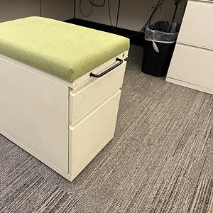 Herman Miller mobile pedestal with green removable cushion for office storage.