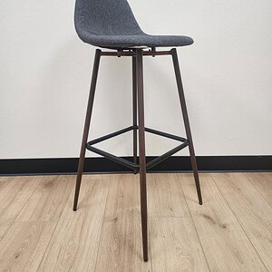 Modern grey fabric bar stool with sleek metal legs and footrest for stylish seating.