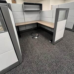 Modular office cubicle with overhead storage and glass panel.