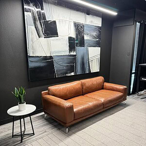 Camel leather sofa with sleek design in contemporary office environment.