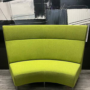 Green tall curved sofa for modern interiors.