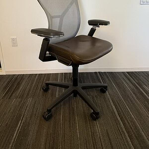 Office ergonomic chair with mesh back and leather seat for comfort.