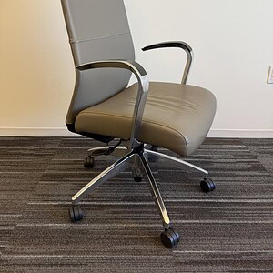 Office chair with chrome accents and leather upholstery for professional workspace comfort.