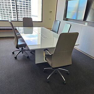 Conference table with sleek glass surface in a professional office setting.