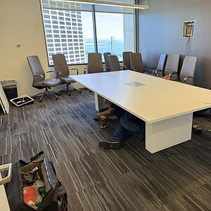 Modern white conference table with built-in power outlets, ideal for corporate meetings.