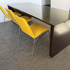 Yellow leather stack chairs around a conference table in modern office setting.