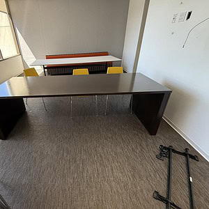 Modern 8x3ft espresso breakroom table in office setting with chairs and natural light.