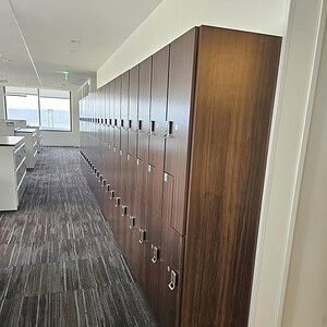 Modern wooden lockers with digital locks in an office corridor.