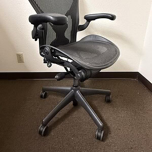 Aeron Posturefit Black ergonomic office chair with mesh back and adjustable features.