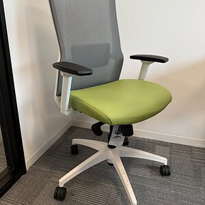 Office chair with green vinyl seat and grey mesh backrest for ergonomic comfort. Perfect for workspa.