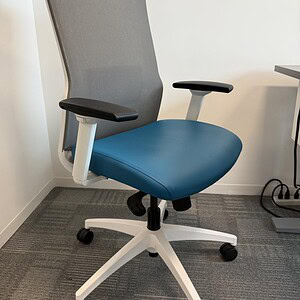 Office chair with blue vinyl seat and gray mesh backrest.