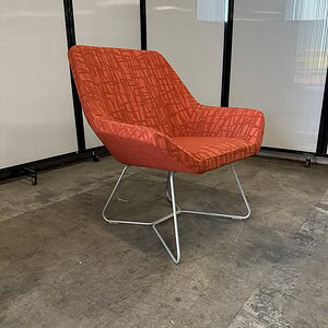 Relaxing orange sled chair with modern design, perfect for contemporary office or lounge spaces.