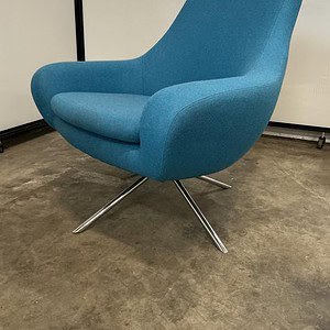 Luxury blue lounge chair with chrome swivel base for modern interiors.