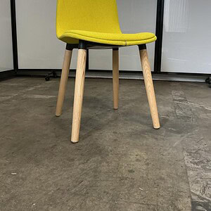 Bright yellow Eames-inspired accent chair with white oak legs for stylish home decor.
