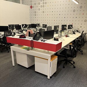 Benching stations with glass partitions for office workspaces.