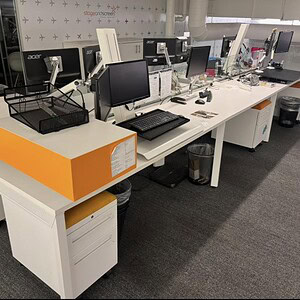 Modern Allsteel glass benching workstation with multiple computer setups.