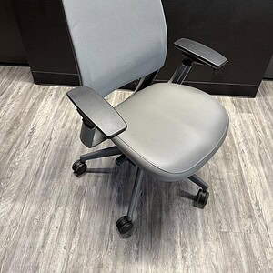 Office ergonomic grey vinyl chair for workspace comfort.