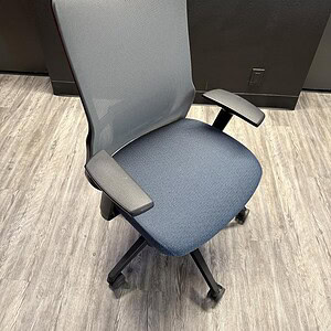 Office ergonomic chair with grey mesh back and navy fabric seat.