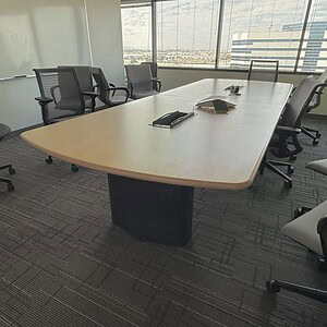 Conference table with white oak finish in a modern office setting.