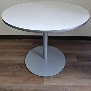 Modern 36-inch round table with sleek silver base by Steelcase Coalesse.