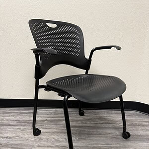 Herman Miller Caper chair in black with stackable design on casters. Perfect for modern office space.