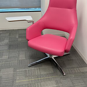 Pink leather swivel lounge chair with armrest and modern design.