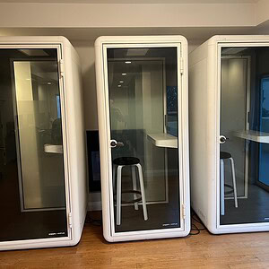White and glass phone booth for private calls and meetings.