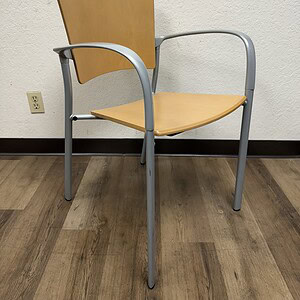 Stackable maple veneer guest chair with silver aluminum frame for versatile office seating.