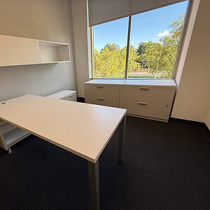 Modern executive U-shaped office with credenza and large window view.