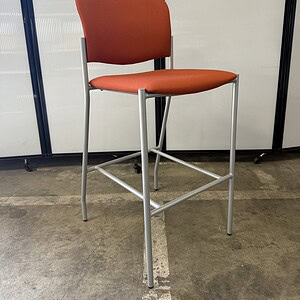 Orange barstool with metal frame for commercial or home use.