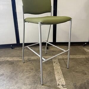 Square-shaped barstool with sage fabric upholstery and metal frame.