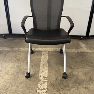 Office chair with black leather seat and mesh backrest.