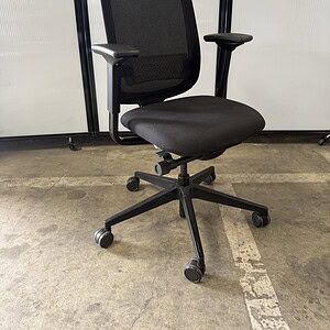 Black mesh back office chair with adjustable armrests and wheels.