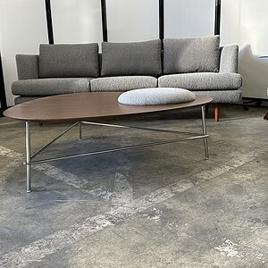 Modern dark walnut veneer coffee table with sleek metal legs in a contemporary living room.