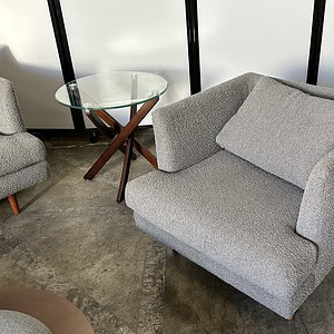 End table with dark wood collapsible legs and glass top, perfect for modern living spaces.