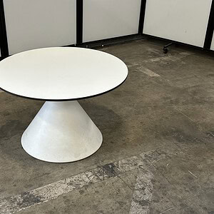 White round table with a conical base, ideal for modern interiors.