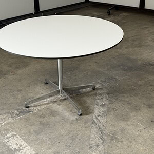 Round white conference table with chrome pedestal base, ideal for modern office spaces and collabora.